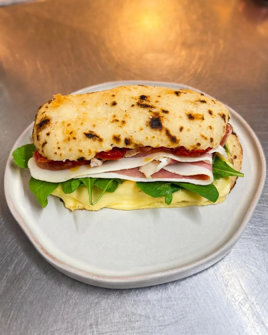 Pan de Ajo JCrudo: pan de ajo con jamón crudo, queso, tomates y rúcula