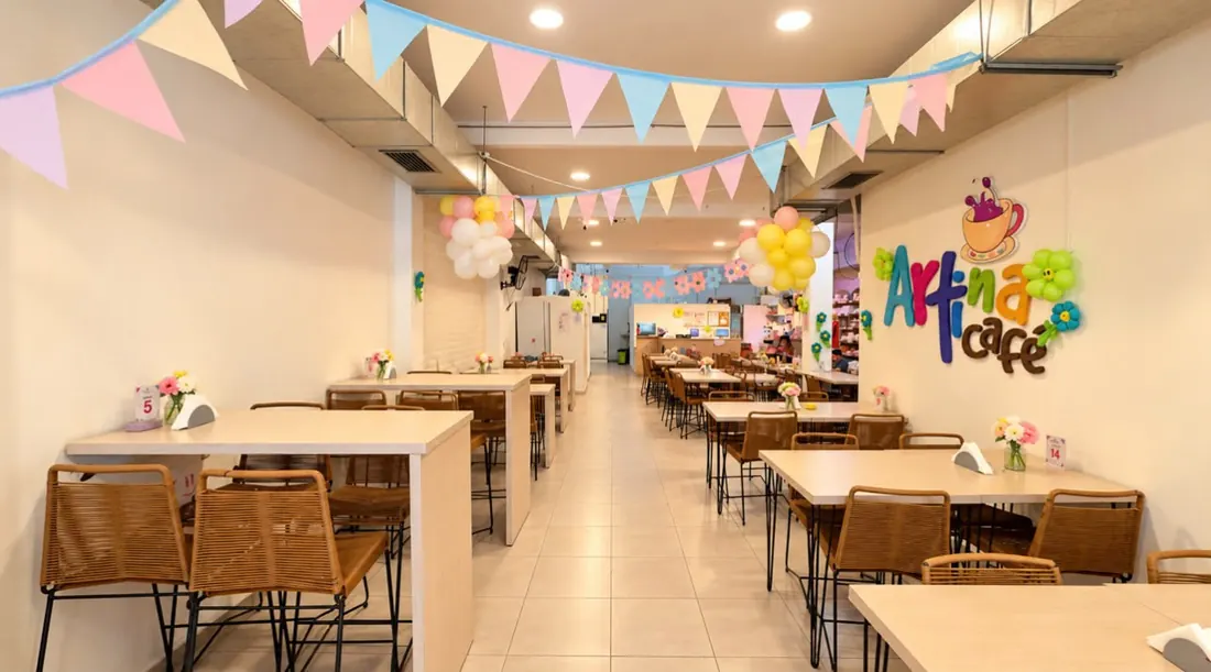 El salón de Artina Café decorado para un cumpleaños, con banderines y globos